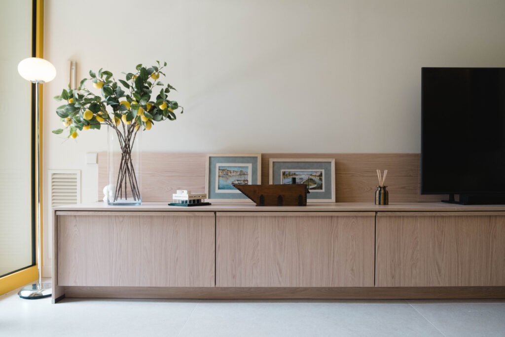 Salón de interiorismo con mueble bajo de madera y un limonero en maceta