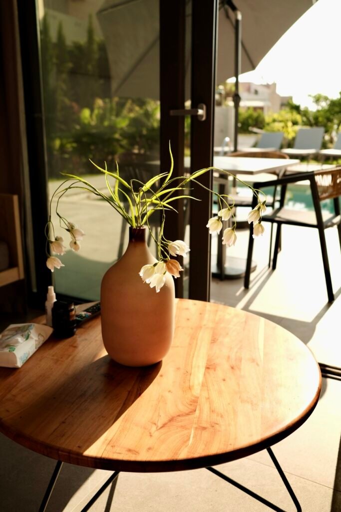 Twin Apartments, Creta: mesa de madera con jarrón a contraluz
