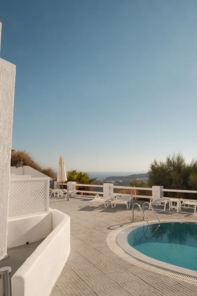 Hotel Artemis Suites, Santorini: tumbonas junto a la piscina y el mar