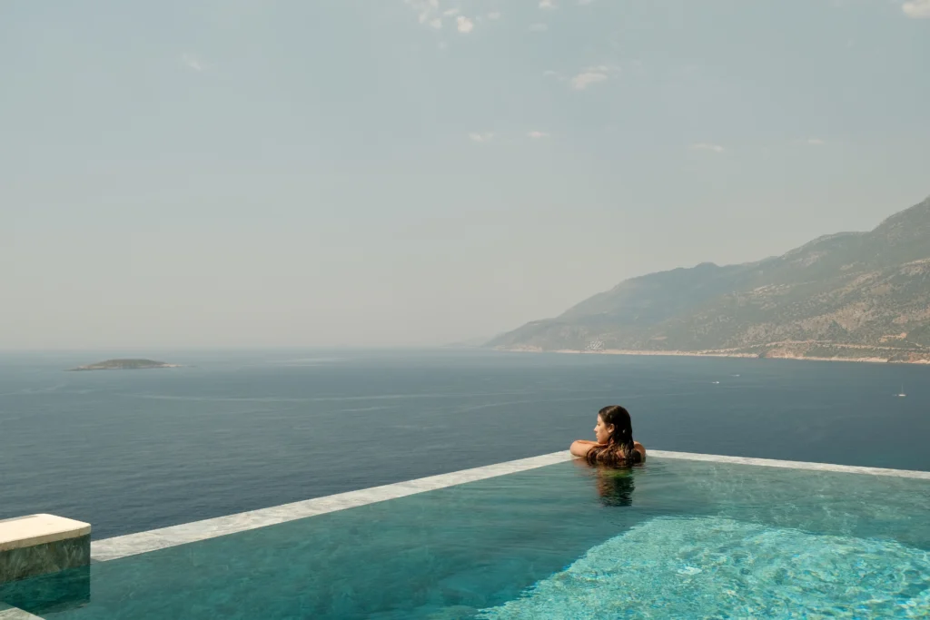 Lyxos Hotel, Kaş: piscina infinita frente a las montañas, con una bañista