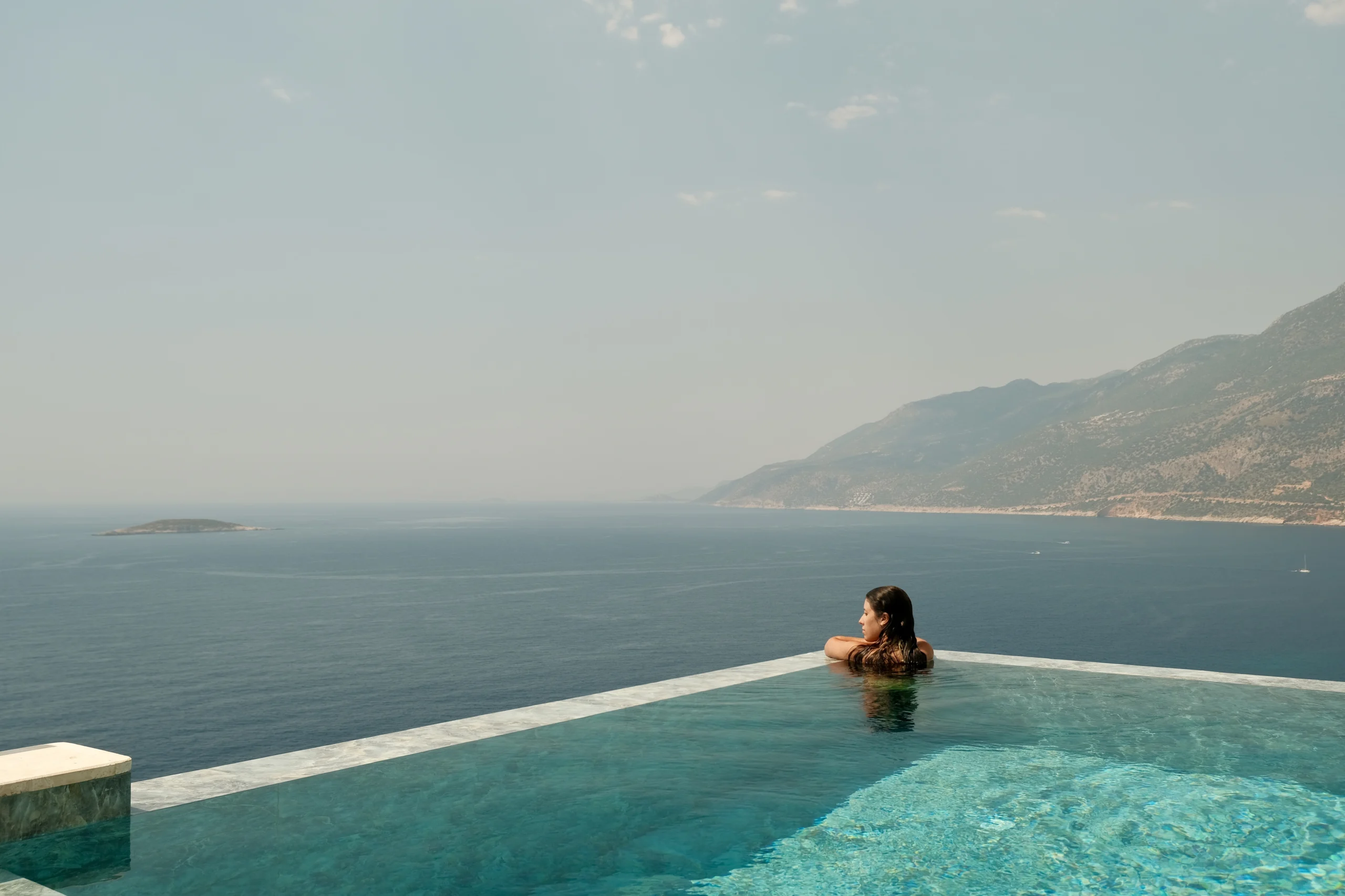 Lyxos Hotel, Kaş: piscina infinita frente a las montañas, con una bañista