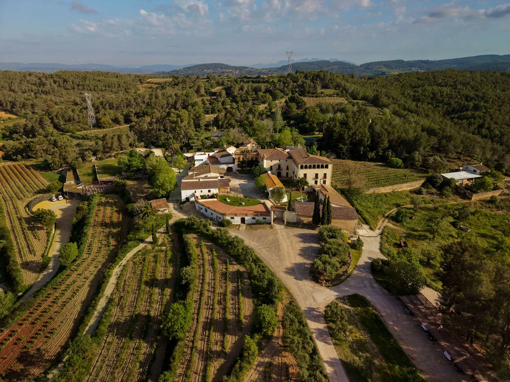 Can Ràfols dels Caus, Penedès: viñedos y masía entre colinas, vista aérea